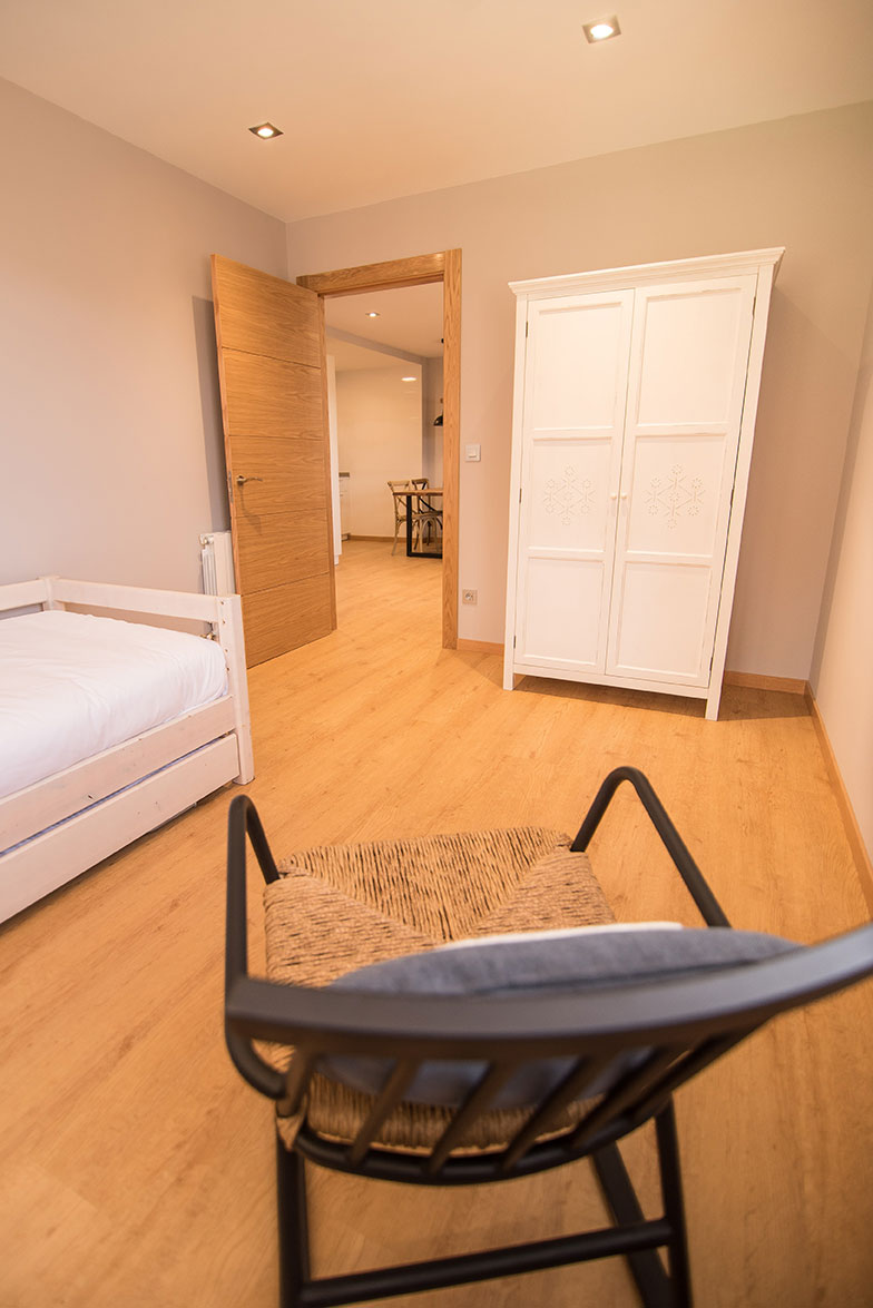 Habitación individual con cama nido, mecedora y armario en apartamento de dos habitaciones - casa rural agroturismo Zumintxaz